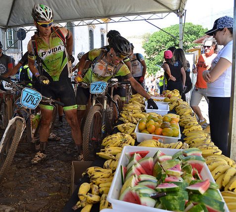Ciclistas tomando fruta (carbohidratos) en un avituallamiento